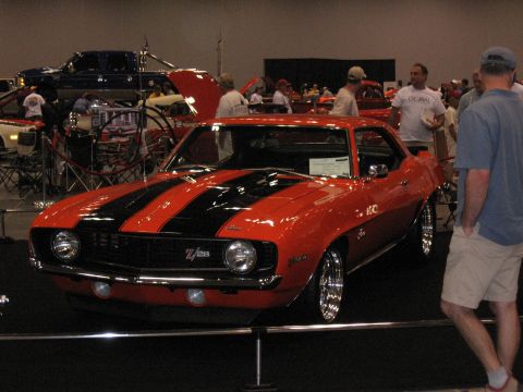 1968 Shelby GT500 - Orange 1969 Chevrolet Camaro Z/28 with black stripes at a car show.