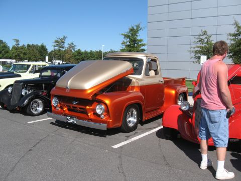 1968 Shelby GT500 - A two-tone 1956 Ford F-100 pickup truck is displayed with its hood open at a car show.