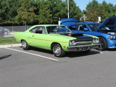1968 Shelby GT500 - A lime green 1970 Plymouth Road Runner is parked next to a blue Dodge Charger at a car show.