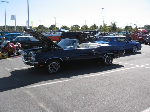 1968 Shelby GT500 - A dark blue convertible with a white interior is parked in a lot, with its hood open, alongside other vehicles.