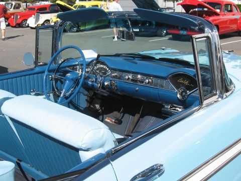 1968 Shelby GT500 - The interior of a classic Chevrolet convertible, a blue dashboard and seats, with other cars visible in the background.
