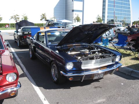 1968 Shelby GT500 - A dark blue 1967 Ford Mustang fastback is displayed with its hood open at a car show.
