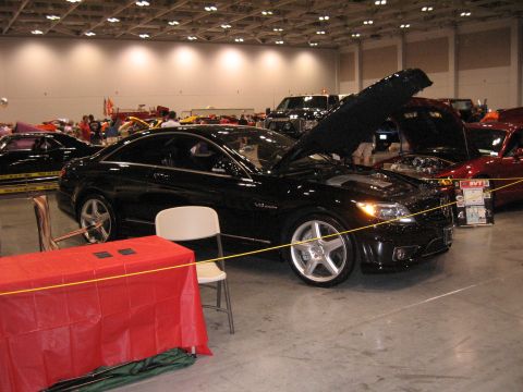 1968 Shelby GT500 - A black coupe is displayed indoors with its hood open, parked next to a red table.