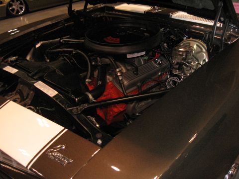 1968 Shelby GT500 - The engine bay of a brown 1969 Chevrolet Camaro is visible, white racing stripes on the fender.