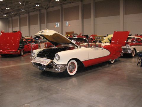 1968 Shelby GT500 - A two-tone convertible is displayed with its hood open at an indoor car show.