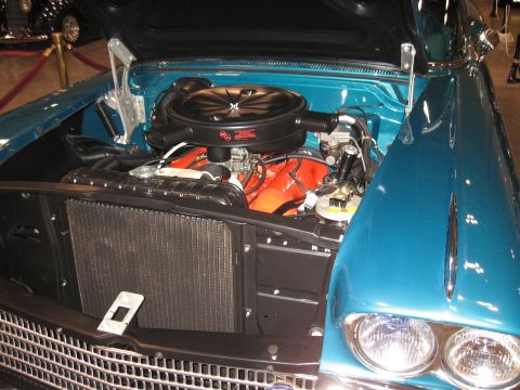 1968 Shelby GT500 - Close-up of a teal car's engine bay, revealing an orange V8 engine and radiator.