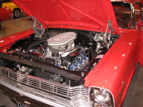 1968 Shelby GT500 - Engine bay of a red classic car, possibly a 1968 model, with a yellow car in the background.