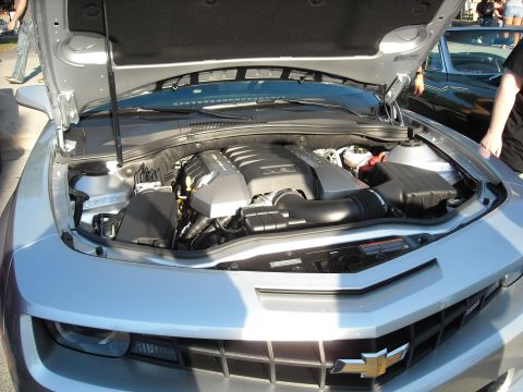1979 Ford F-150 - The engine compartment of a silver Chevrolet Camaro is displayed with the hood raised.