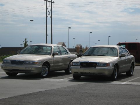 2000 Mercury Grand Marquis - Two Mercury Grand Marquis sedans are parked in a lot under a cloudy sky.