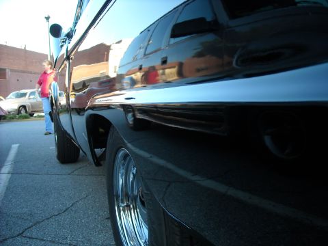 1979 Ford F-150 - A black pickup truck with chrome accents is parked on asphalt, with reflections visible on its polished surface.