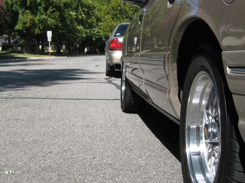 2000 Mercury Grand Marquis - A tan 2000 Mercury Grand Marquis is seen from the side, custom chrome wheels and another vehicle in the background.