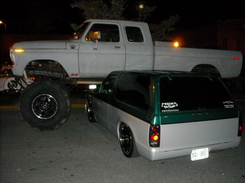1979 Ford F-150 - A lifted 1979 Ford F-150 truck is parked next to a lowered SUV at night.