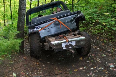 1988 Chevrolet Blazer - A Jeep Wrangler navigates a challenging off-road trail, its rear axle high off the ground.
