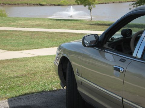 2000 Mercury Grand Marquis - Side view of a 2000 Mercury Grand Marquis parked near a pond with a fountain.