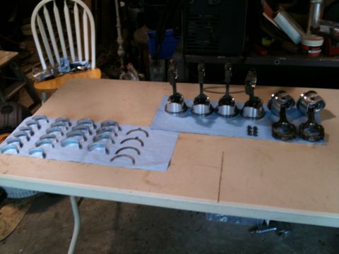 1993 Toyota 4Runner - Engine components, including bearings and pistons, are laid out on a table for inspection or assembly.