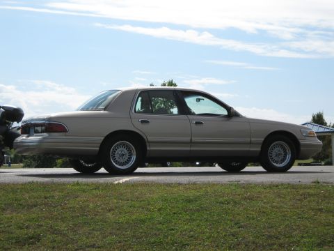2000 Mercury Grand Marquis - A tan 2000 Mercury Grand Marquis sedan is seen from the side on a sunny day.