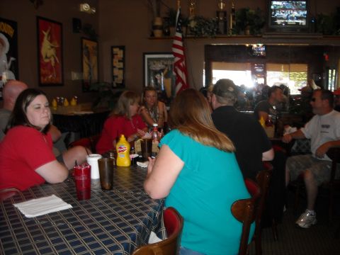 1979 Ford F-150 - A group of people are gathered around tables in a casual dining establishment, with a television visible in the background.