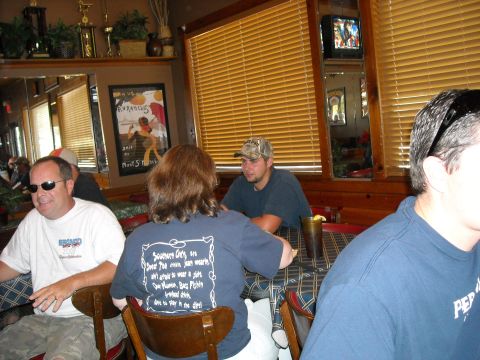 1979 Ford F-150 - A group of people are seated at tables in what appears to be a restaurant or diner setting.