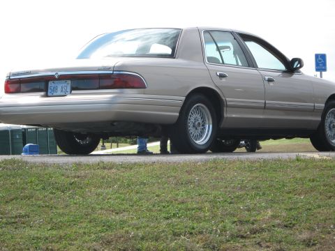 2000 Mercury Grand Marquis - Rear view of a tan 2000 Mercury Grand Marquis sedan, wire wheels and a license plate reading '548 ASL'.