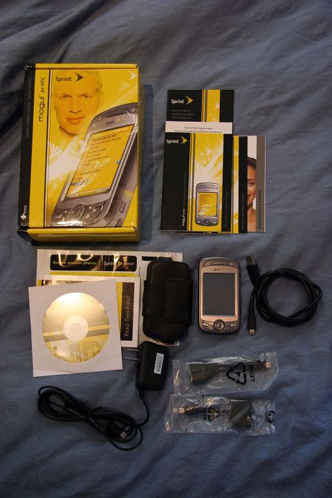 1992 Ford Taurus - The Sprint Mogul by HTC smartphone is shown with its complete accessory package, including a charger, cables, software CD, and user manual.