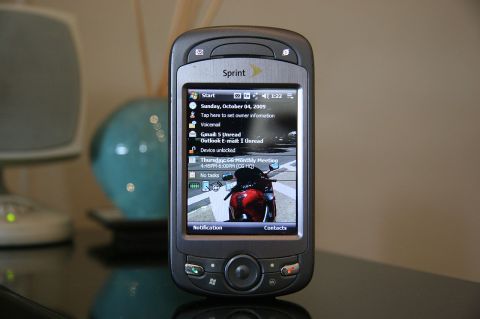 1992 Ford Taurus - A Sprint mobile phone is shown with its screen displaying the date, time, and a motorcycle wallpaper.