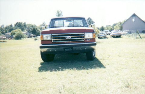 1987 Ford F-150 - Front view of a red 1987 Ford F-150 pickup truck with '4x4' badging.