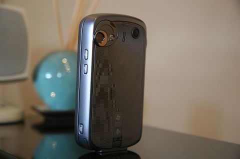 1992 Ford Taurus - A close-up shot of the rear of a cell phone, with a decorative vase visible in the blurred background.