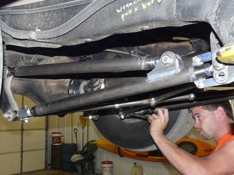 1994 Ford F-150 - Underside view of a lifted truck showing a four-link rear suspension with heim-jointed tubular bars, a solid rear axle housing and drivesha…
