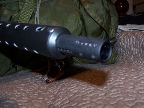 1986 Ford Bronco - A close-up view of a gun barrel, with a green bag and quilted surface visible.