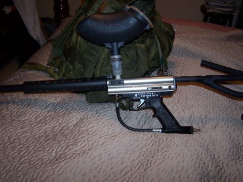 1986 Ford Bronco - A paintball gun with a black barrel and hopper is displayed on a patterned surface.