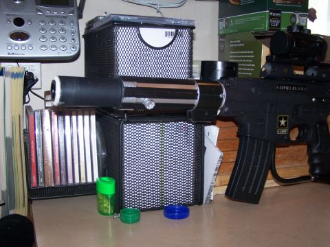 1986 Ford Bronco - A toy gun with a scope and extended barrel sits on a counter next to a stack of CDs and a cordless phone.