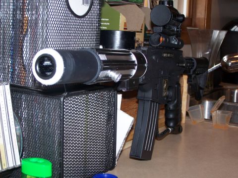 1986 Ford Bronco - A modified rifle with a scope, silencer, and magazine is displayed on a counter.
