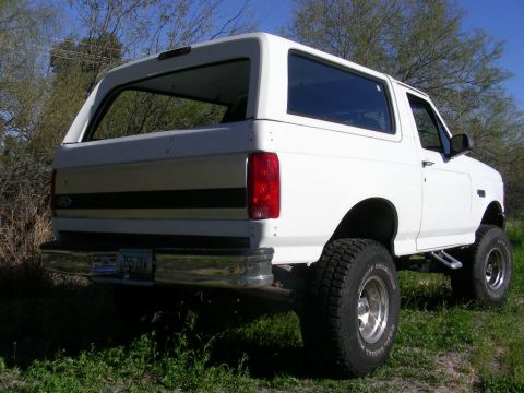 1996 Ford Bronco - This 1996 Ford Bronco features a lifted suspension and aftermarket wheels, viewed from the rear three-quarter angle.