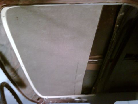 1979 Ford F-250 - The headliner material is being fitted into the vehicle's interior frame.
