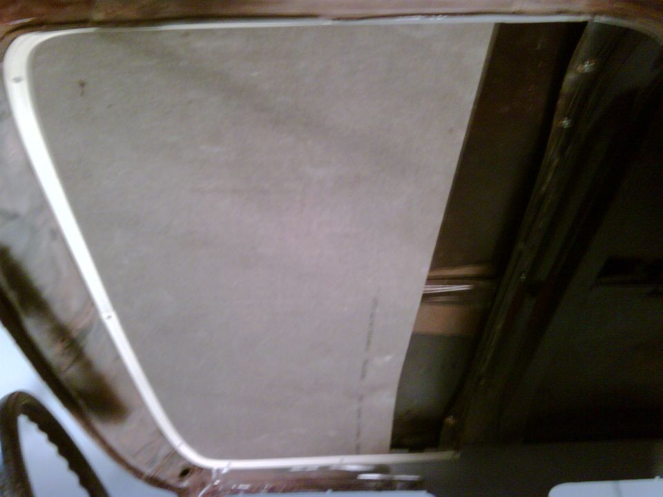 Interior shot of a vehicle's headliner being installed, showing the material and frame