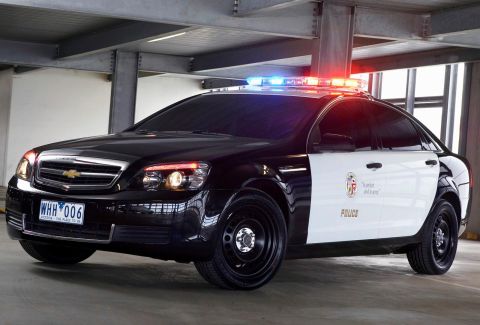 1993 Ford Taurus - A black and white police car with a light bar is parked indoors, showing its front 3/4 view.