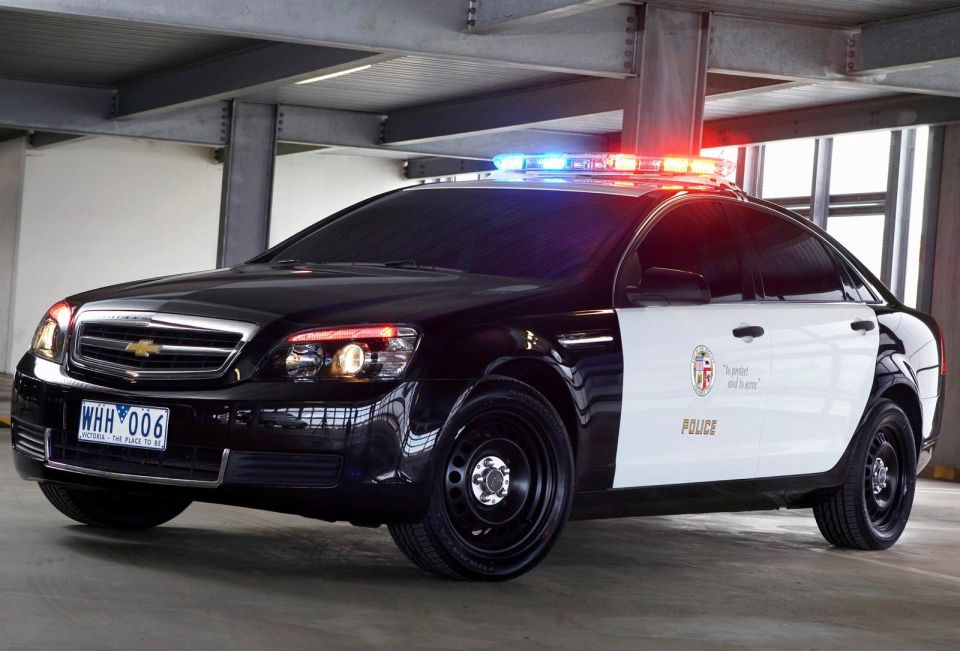 Black and white police car with light bar, front 3/4 view