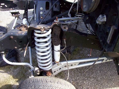 1990 Ford Bronco - The front suspension and frame components of a vehicle are visible in this close-up shot.