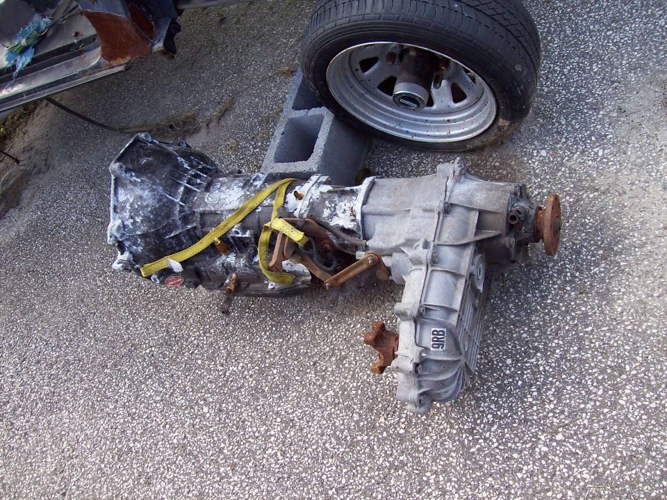 Transmission and transfer case with yellow strap, part number 9RB visible