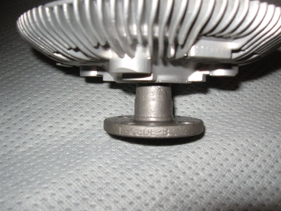 Metal fan clutch with stamped numbers '1-C80E-B' on its flange