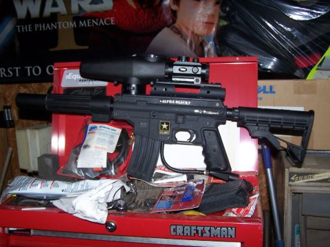 1986 Ford Bronco - A black paintball gun with tactical accessories rests on a red toolbox.