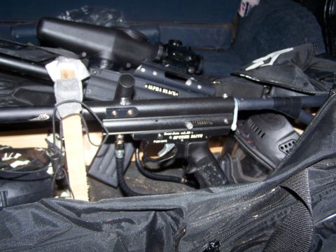 1986 Ford Bronco - Close-up of paintball equipment, including a marker and protective mask, stored in a bag.