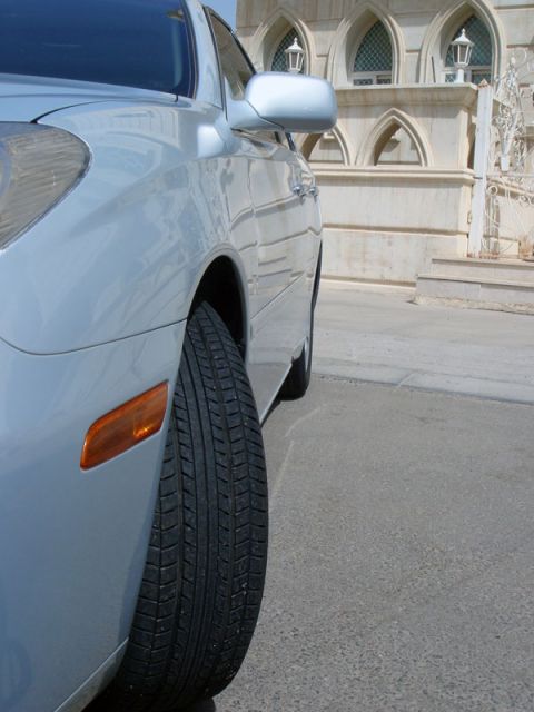 2002 Lexus ES 300 - Front quarter view of a silver sedan, showing the fender and tire. A building is visible behind.