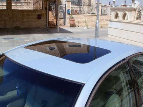 2002 Lexus ES 300 - The sunroof of a car is visible, reflecting the surrounding buildings.