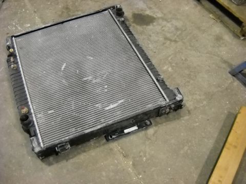 1986 Ford C-350 (Centurion Conversions) - A radiator part is shown lying on a concrete floor.