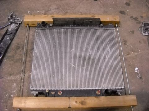 1986 Ford C-350 (Centurion Conversions) - A vehicle radiator is shown, disassembled and supported by wooden blocks.