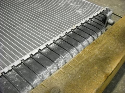 1986 Ford C-350 (Centurion Conversions) - Close-up of a vehicle radiator, showing signs of corrosion on its fins and tanks.