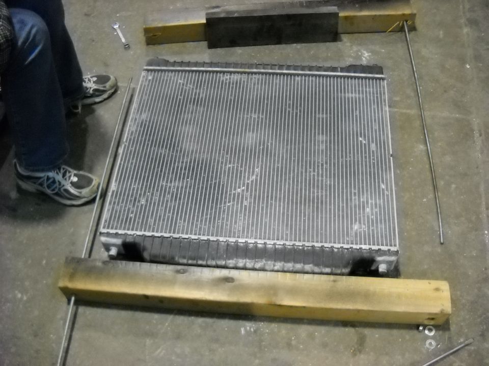 Radiator on concrete floor with wooden supports and metal rods