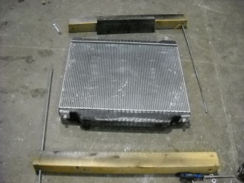 1986 Ford C-350 (Centurion Conversions) - A vehicle radiator is shown on a workshop floor, possibly awaiting repair or replacement.