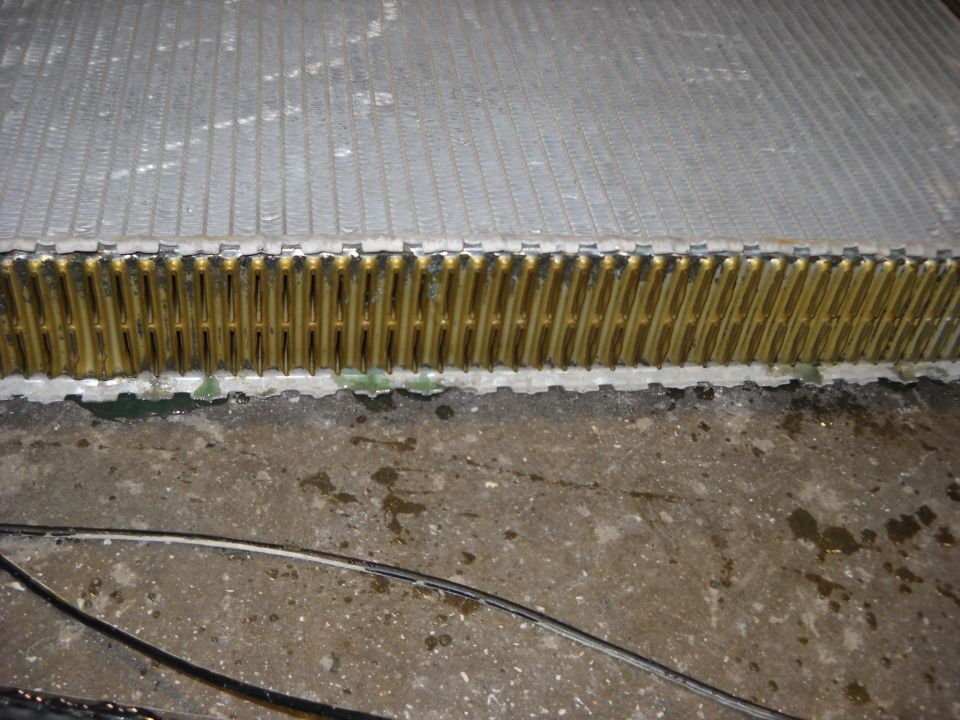 Close-up of a vehicle radiator with visible fins and tubes